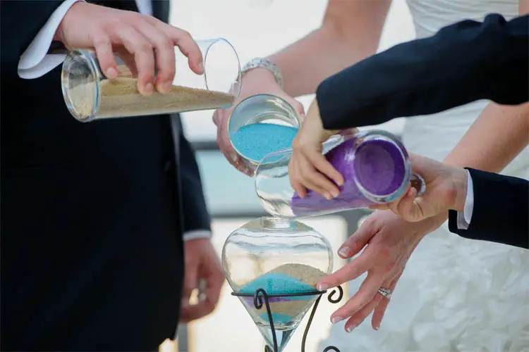 Hochzeitspaar füllt während der freien Trauung Sand in eine Vase