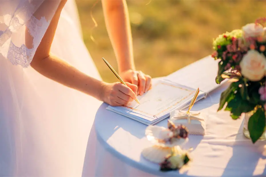 Die Braut leistet die Unterschrift zur standesamtlichen Eheschließung