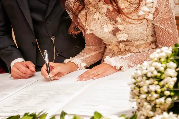 Brautpaar unterschreibt beim Standesamt
