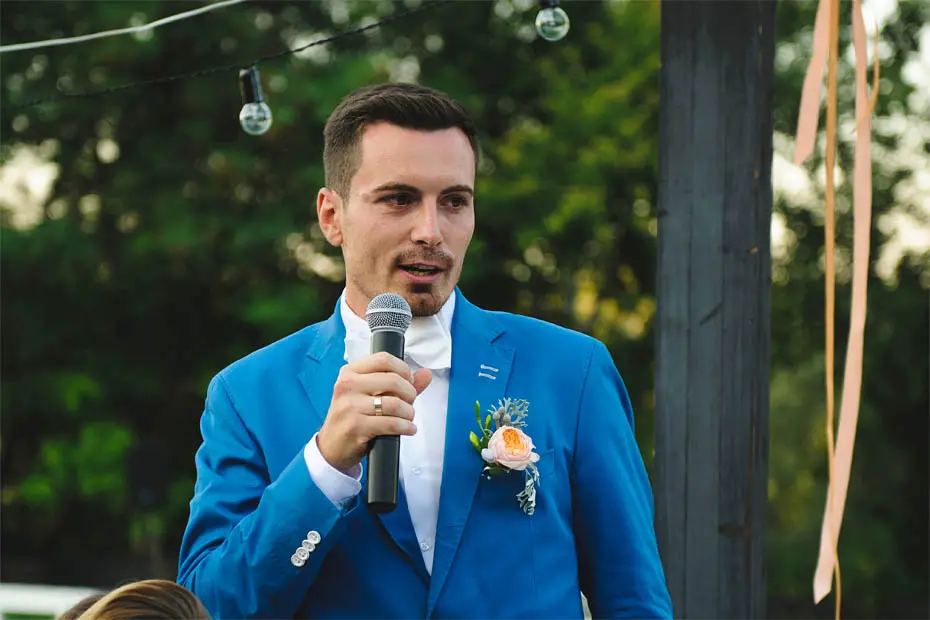 Bräutigam in blauem Anzug hält seine Hochzeitsrede