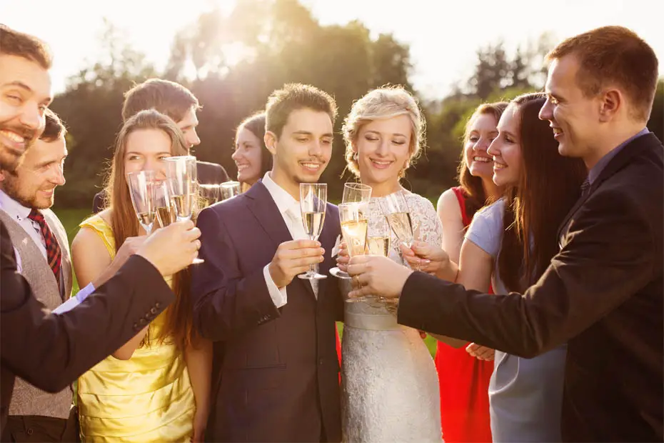 Sektempfang zur Hochzeit: Braut und Bräutigam stoßen mit ihren Gästen an