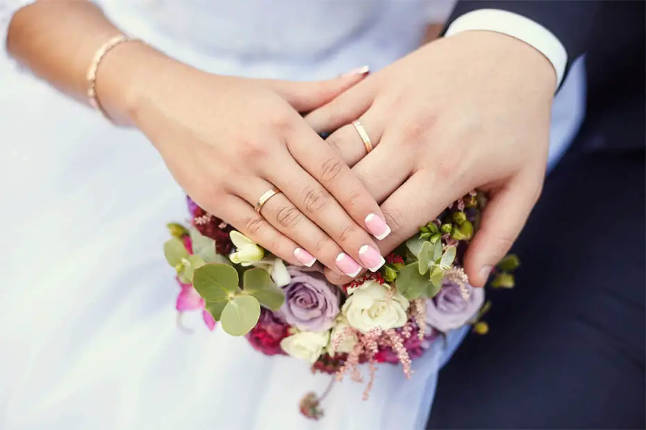 Braut und Bräutigam zeigen stolz ihre Ringe nach der standesamtlichen Hochzeit