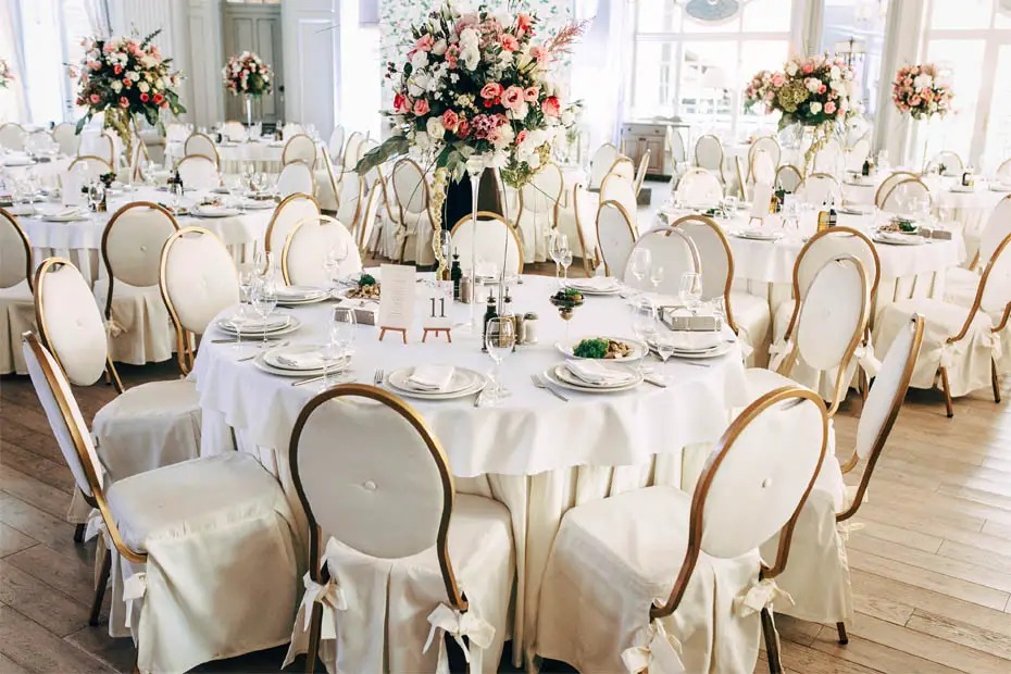 Hochzeitssaal mit vielen hübsch dekorierten und nummerierten Tischen