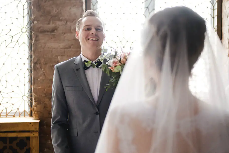 Der First Look: Bräutigam strahlt glücklich
