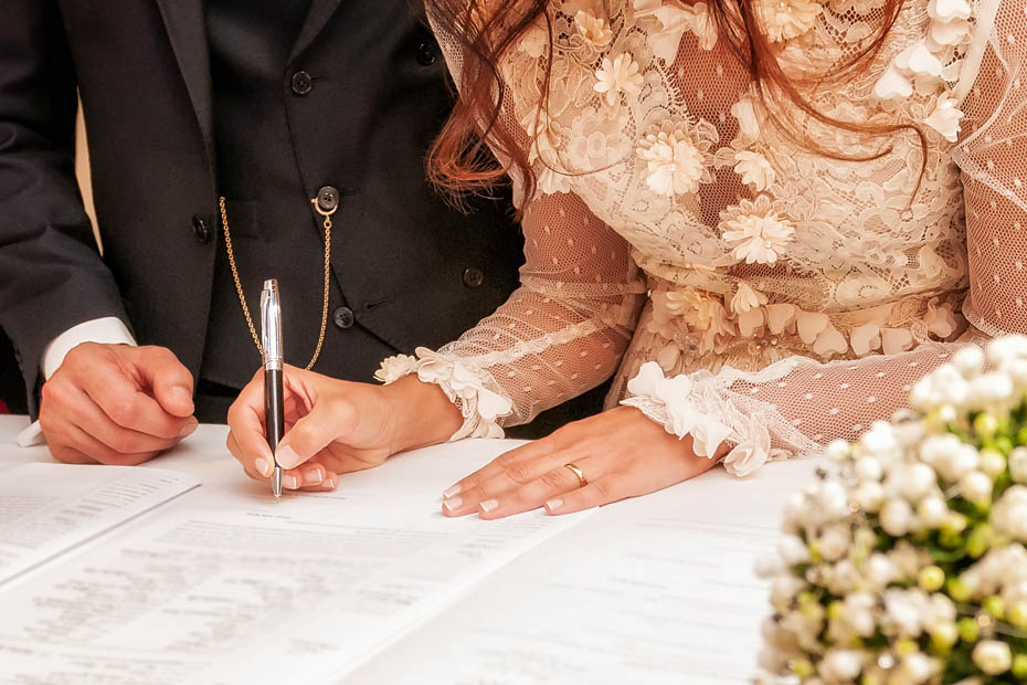 Das Brautpaar leistet die Unterschrift beim Standesamt